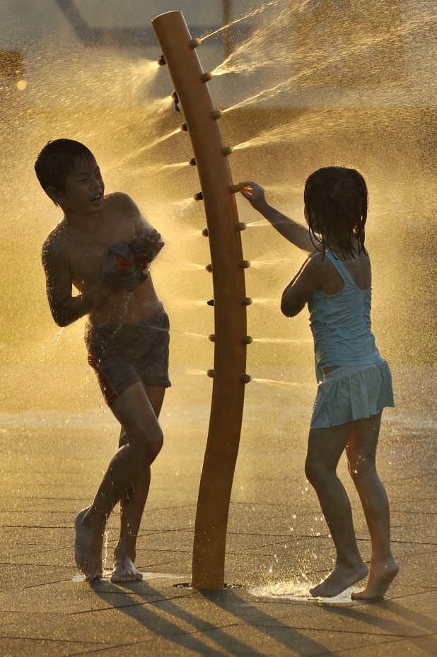 夕陽斜光下,兄妹倆在希望噴泉內盡情嬉戲也嬉夕!